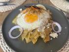 A breakfast staple, chilaquiles are tortilla chips smothered in spicy sauce with an egg on top