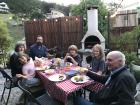 Cam and Zinn eating dinner with their family at their grandparents' house in the ecovillage