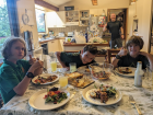 Cam, Zinn, their friend and their dad enjoying a delicious dinner