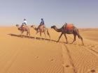 My mom and me on our camels as we walk leave camp after a night of drumming the Sahara