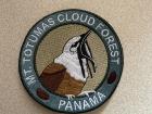 The three-wattled bellbird is featured in the logo of Mount Totumas, seen on this iron-on patch I bought as a souvenir. The three black strings hanging from its bill are the wattles, similar to the ones on a turkey