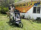 Mulget Amaru standing in front of his in-progress mural of an Ethiopian sunset and animals like lions, ostriches and antelope