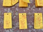 People visiting the Confucian temple write prayers on slips of paper wishing for success on their school exams