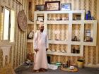 A local host stands inside his traditional majlis, a traditional Omani sitting room