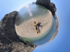 An Insta360 shot captures our kayak landing on a hidden beach surrounded by towering cliffs and clear turquoise water