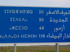 Tamazight writing on the left and Arabic on the right on a road sign in Morocco 