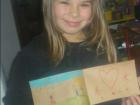 Greta holding a drawing she made in art class
