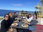 Ship's crew members eating on the deck on a sunny day