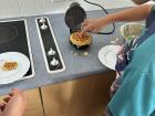 Teaching a student how to make waffles in the Food Technology classroom