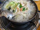 Knife-cut noodles boiling over a burner on the table; it cooked for ~5 minutes before we could enjoy it!