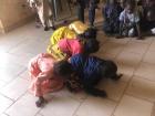 Children at the local kindergarten practice using their lungs in a competition to blow objects using a straw. 