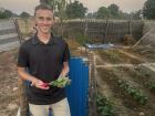 My husband shows off a radish that has grown nicely. While radishes grow really well here, the few people we've asked to try them don't like the flavor. Oh well, more for us!