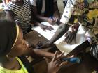 Teen girls work on a project together at school. While classes are not segregated, it would be odd for a girl and boy to do a project together or be seated at the same desk as the culture and society very much encourages separation of the sexes.