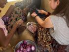 My host sisters Hawa and Sirial teach me how to cut onions in my hand. We gifted our host family a cutting board and showed them how to minimize the chances of cutting their hands. They have not adopted it as they are too used to this in-hand-method. 