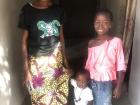 Famita stands with her mom, Hawa, and her little brother Theirno in their home. 