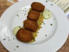 A plate of spinach "croquetas" filled with cheese, on top of rice