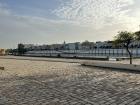 People sitting on the side of the Guadalquivir River, enjoying the view