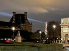 A glimpse of the Eiffel Tower sparkling outside of the Louvre 