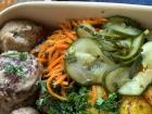 Meatballs, potatoes and pickles in a to-go tray