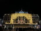 Large hotel lit up with lights to resemble curtains, featuring a large Christmas tree