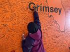 Signing the Grímsey wall at a shop on Grímsey Island