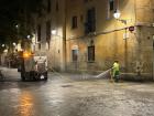 A street cleaner hosing down the street at night