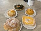 Ensaimadas with chocolate (left) and custard (right) with assorted savory tarts behind