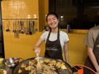 A picture of me stirring paella, a Spanish rice dish, during a cooking class