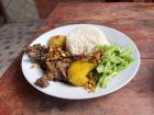 A plate of fried guinea pig, rice, potatoes, and salad