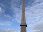 An obelisk stands at the Place de la Concorde in Paris, France in front of the National Assembly