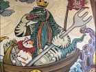 A painting in a cafe of a Komodo dragon eating a doughnut!