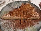 Here is a homemade cheesecake topped with pears and chocolate powder.