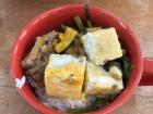 This school lunch had pork, spinach and egg