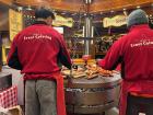 Bratwurst is often prepared on these giant hanging grills, and served hot in a bun