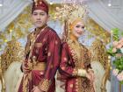 Dressed in rich red and gold songket, the bride and groom embody Malay heritage