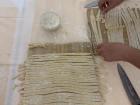 Here is a picture of a cooking class learning to make tagliatelle, a type of Italian pasta!
