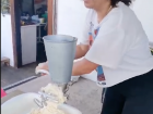 Grinding up the corn kernels to turn later into humitas