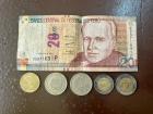 A 20 sol bill next to coins for 1 sol, 2 soles, 5 soles and 10 cents.
