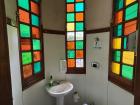 A restroom with green, orange, and yellow stained glass