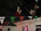 A person at the party waving the Mexican flag on the rooftop