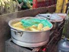 This is a vendor selling corn. All of the corn is kept warm in the large pot.