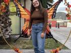 This is me at a Dia de Muertos event, standing next to a monarch butterfly decoration. Monarch butterflies can also represent migration, so here it can represent the journey from life to death