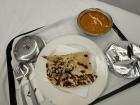 Room service dinner of garlic naan (a type of bread) with chicken tikka masala