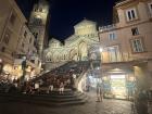 People fill the staircase under the night lights of one of Italy’s most beautiful coastal churches
