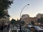 Golden hour in Barcelona: sun setting behind the city, taxis on the street and steps leading down to the Metra