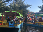 Bright and colorful trajineras (boats) float along the canals of Xochimilco, where locals and visitors enjoy music, food, and celebrations.