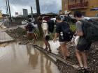 Some volunteers adapting to the flooding by walking over a puddle on a construction beam. 