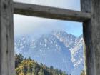 Great view of the Alps through a window in the fence along the side of the restaurant's outdoor seating area