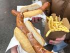 Yummy bacon covered bratwurst with a side of fries