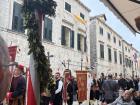 People march through the streets of Dubrovnik carrying colorful banners and crosses during the celebration. Many participants wear traditional clothing that has been part of the festival for hundreds of years